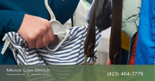 Woman shoplifting a t-shirt off a hanger